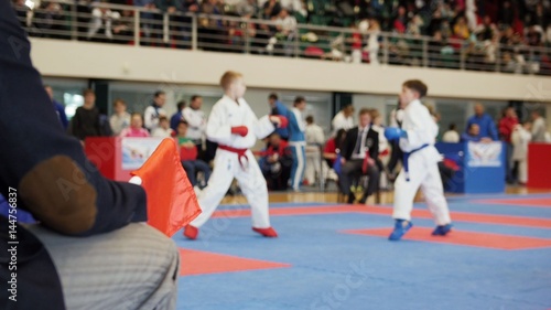 Martial art competitions- karate - judge coaches looking at female teenager's karate fighting