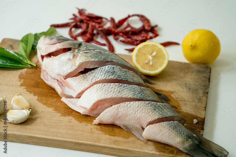 Preparing for Seabass steam with lemon, garlic and chili - Thai food, isolated on white background Preparing for Seabass steam with lemon, garlic and chili - Thai food, isolated on white background