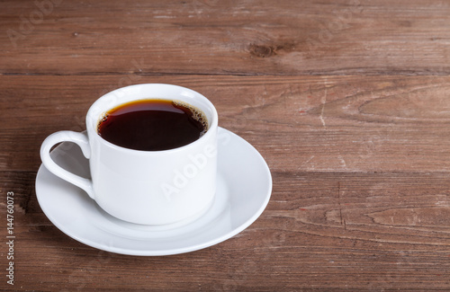 White cup of tea on old wooden table