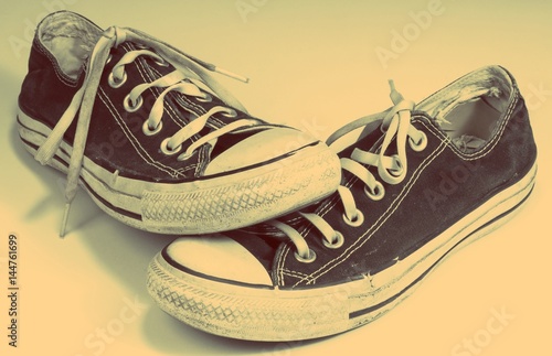 A pair of dirty sneakers on top of retro textured background