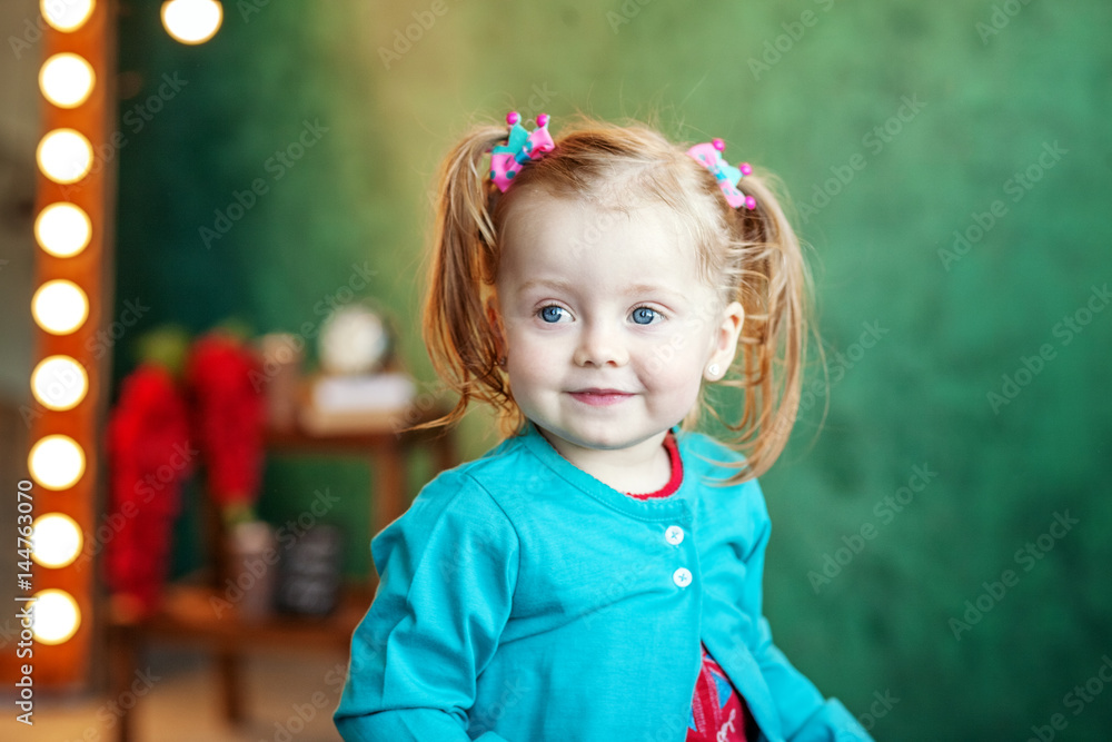 Happy little girl in shorts sitting on a chair. The concept of childhood and lifestyle. Happy little girl in shorts sitting on a chair. The concept of childhood and lifestyle.