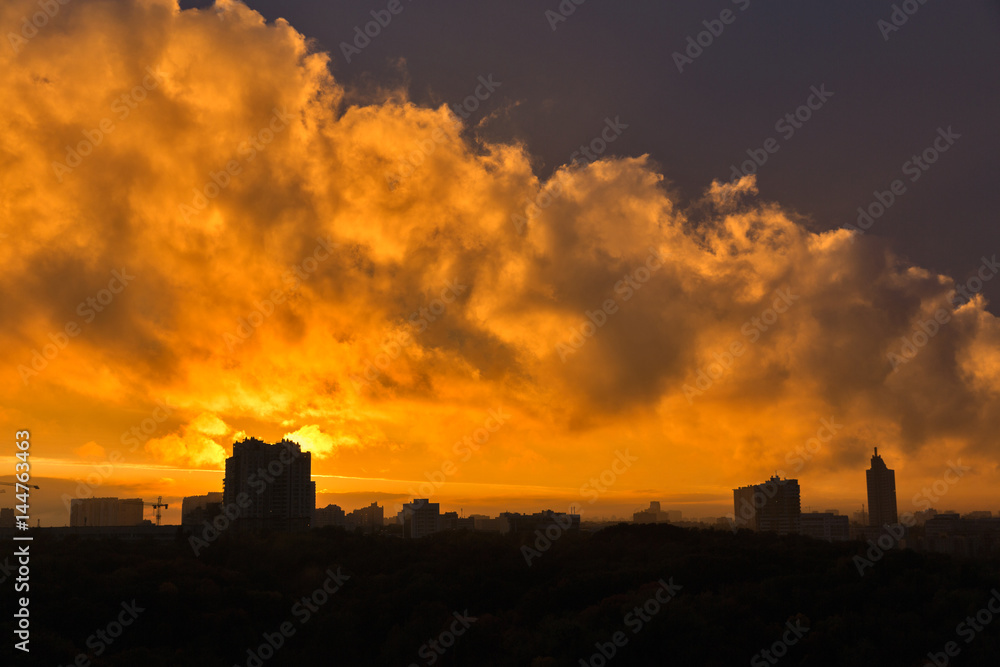 Urban sunset skyline with dramatic orange clouds.
