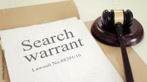 Search warrant document with gavel placed on desk of judge in court