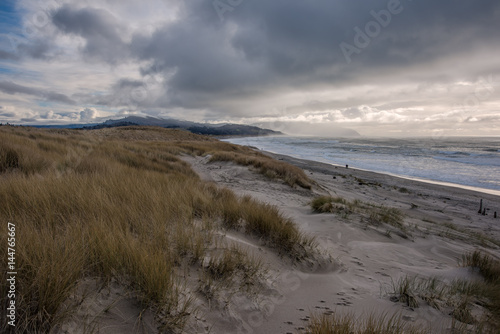 Sand dunes with people walking on beach, Cape Kiwanda, Oregon