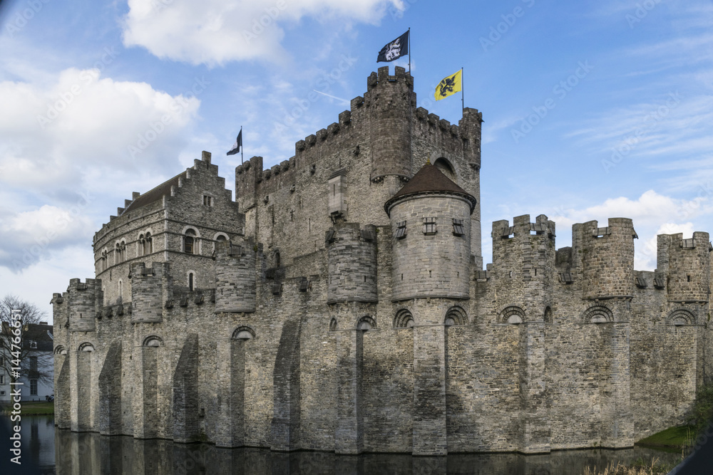 Towers and walls of the medieval Gravensteen castle in Ghent, Belgium, on a sunny March morning.