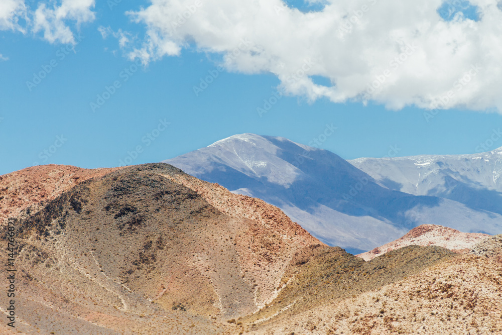 Orange hill with peaks behind in Catamarca, Argentina