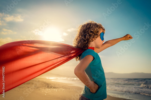Superhero child on the beach. Summer vacation concept