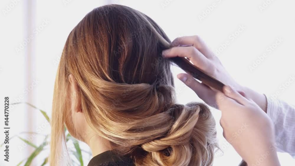 Hair stylist creating a hairstyle for a beautiful woman in salon Hair stylist creating a hairstyle for a beautiful woman in salon