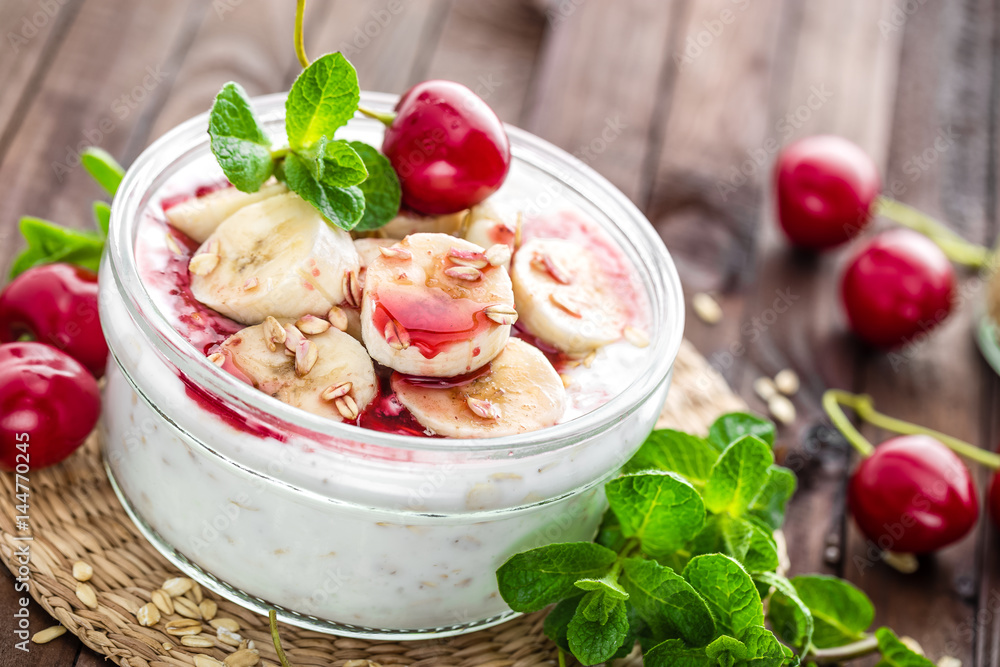 Fresh yogurt with cherry, banana and oats, delicious dessert for healthy breakfast Fresh yogurt with cherry, banana and oats, delicious dessert for healthy breakfast