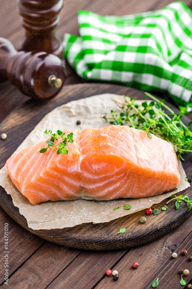Raw salmon fish fillet on wooden board closeup Raw salmon fish fillet on wooden board closeup