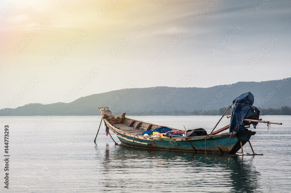 Tranquil scenery with traditional asian boat in sea during sunset