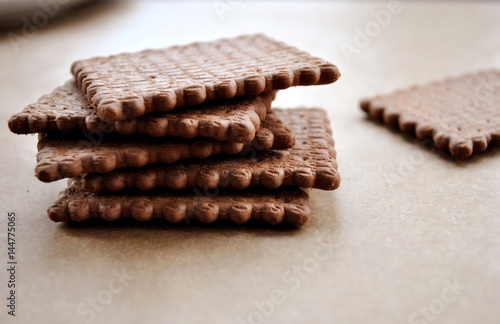 Stack of brown biscuits on light background.