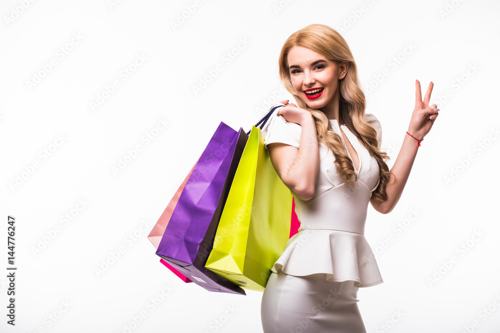 Beautiful young women with bags with victory sign, shopping concept on white background Beautiful young women with bags with victory sign, shopping concept on white background
