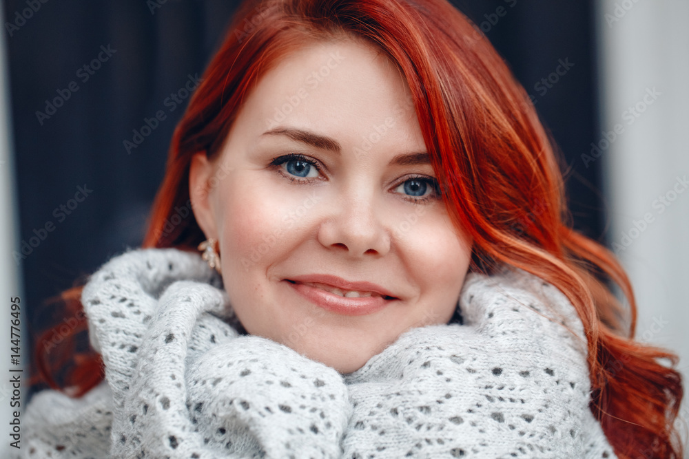 Closeup portrait of smiling middle aged white caucasian woman with waved curly red hair in knitted scarf shawl, looking in camera,outside park, beauty fashion lifestyle concept Closeup portrait of smiling middle aged white caucasian woman with waved curly red hair in knitted scarf shawl, looking in camera,outside park, beauty fashion lifestyle concept