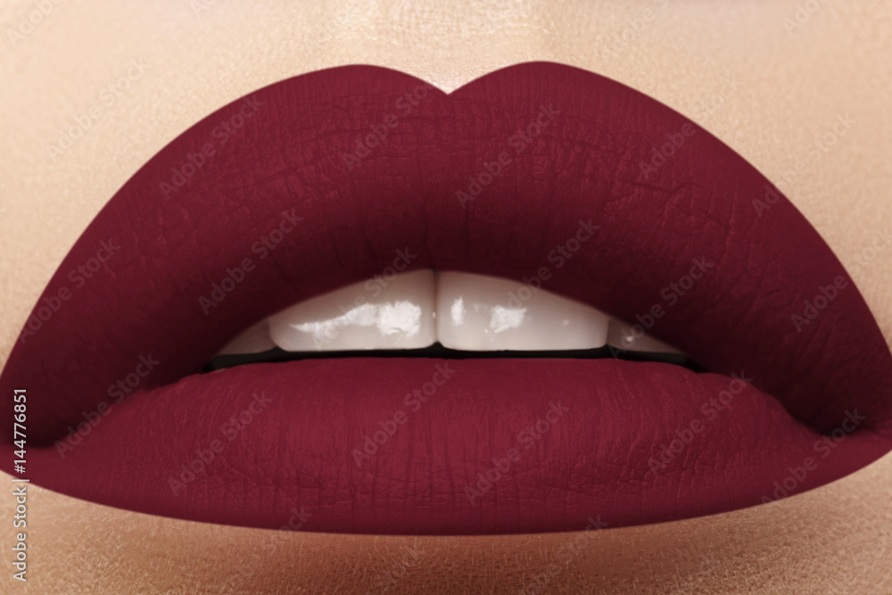 Cosmetics, makeup. Bright lipstick on lips. Closeup of beautiful female mouth with dark red lip makeup. Part of face