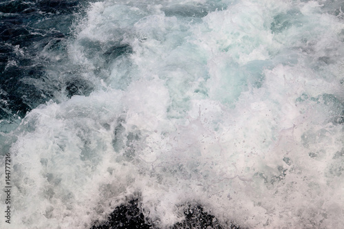 Trail on water surface behind of cruise ship