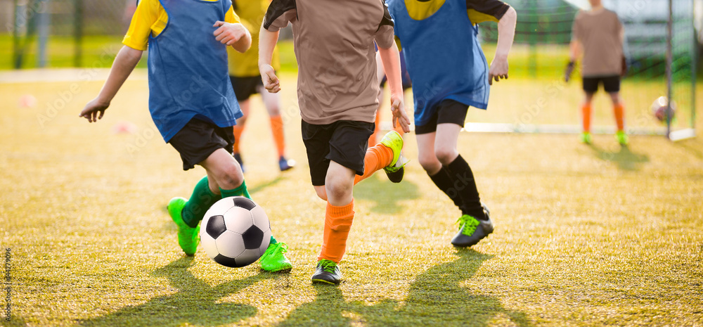 Kids Playing Soccer Game Tournament. Football Soccer Match for Children. Boys Running and Kicking Football. Youth Soccer Coach in the Background Kids Playing Soccer Game Tournament. Football Soccer Match for Children. Boys Running and Kicking Football. Youth Soccer Coach in the Background