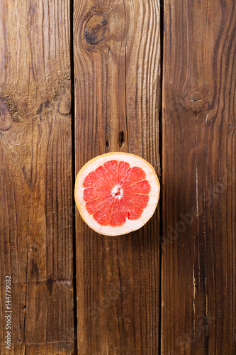 Half a grapefruit on a wooden background