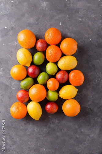 Citrus fruits on gray abstract background. Оrange, lemon, grapefruit, mandarin, lime. Mixed festive colorful tropical and citrus fruit. Healthy eating photo concept. Copyspace © avdeyukphoto