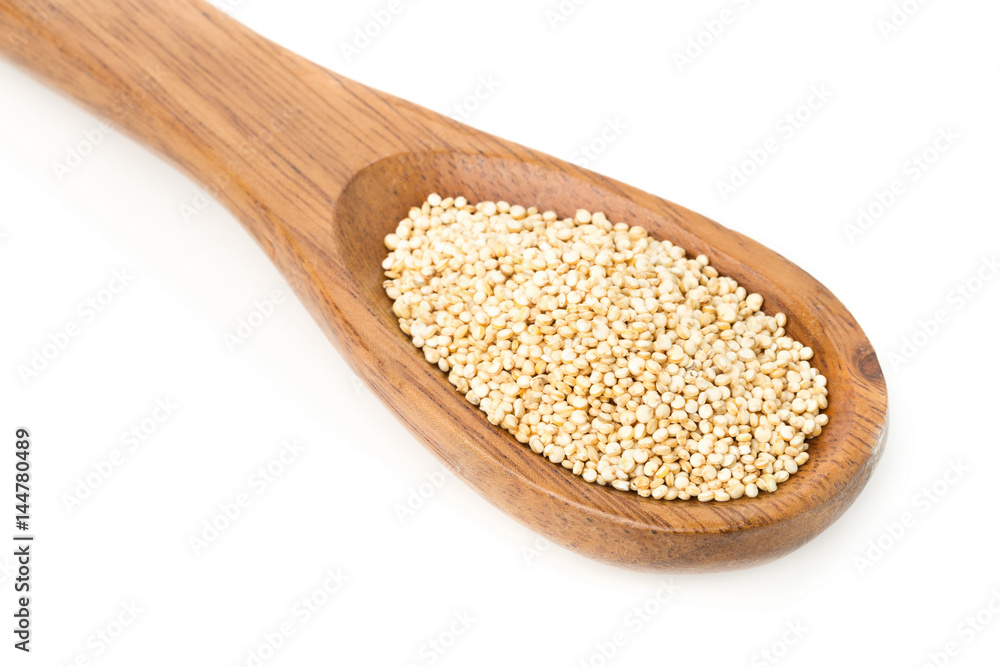 Raw, uncooked, whole quinoa seed in wooden spoon Raw, uncooked, whole quinoa seed in wooden spoon