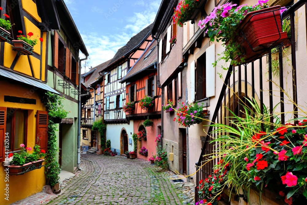 Quaint colorful cobblestone lane in the Alsatian town of Eguisheim, France
