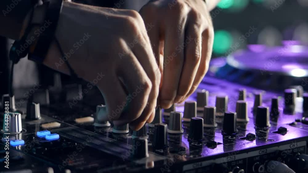 DJ playing music at the nightclub. Hands close up shot. 4K.