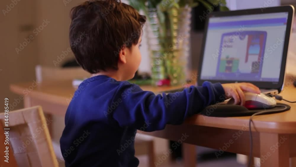 Kid at home wave his hand and turn to his computer screen Kid at home wave his hand and turn to his computer screen