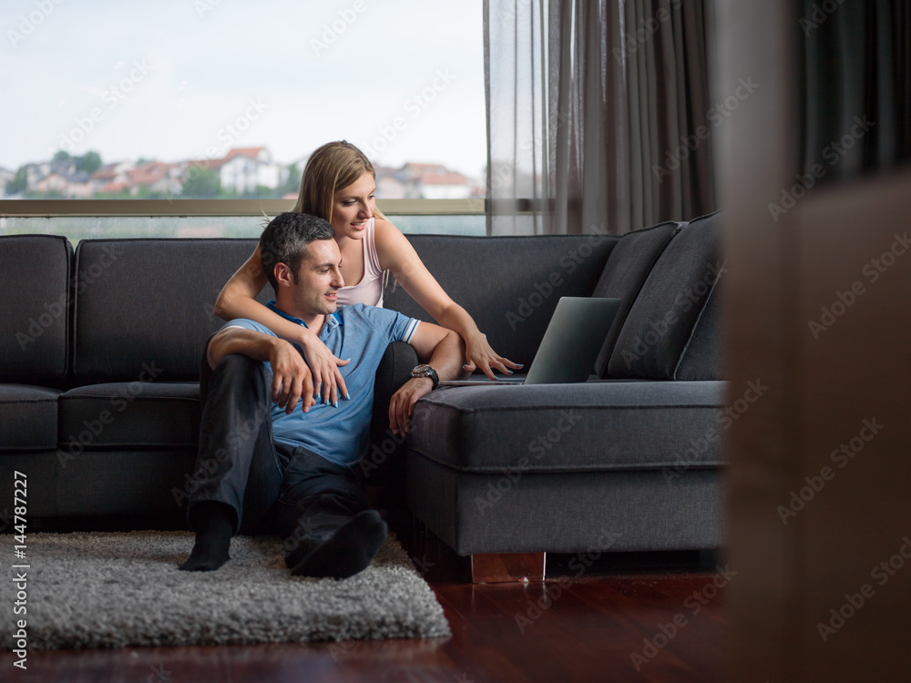 Obraz premium Attractive Couple Using A Laptop on couch