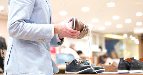 Man Chooses Shoes At Shoe Store