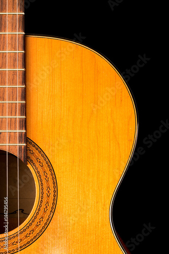 The old classical guitar on black background.