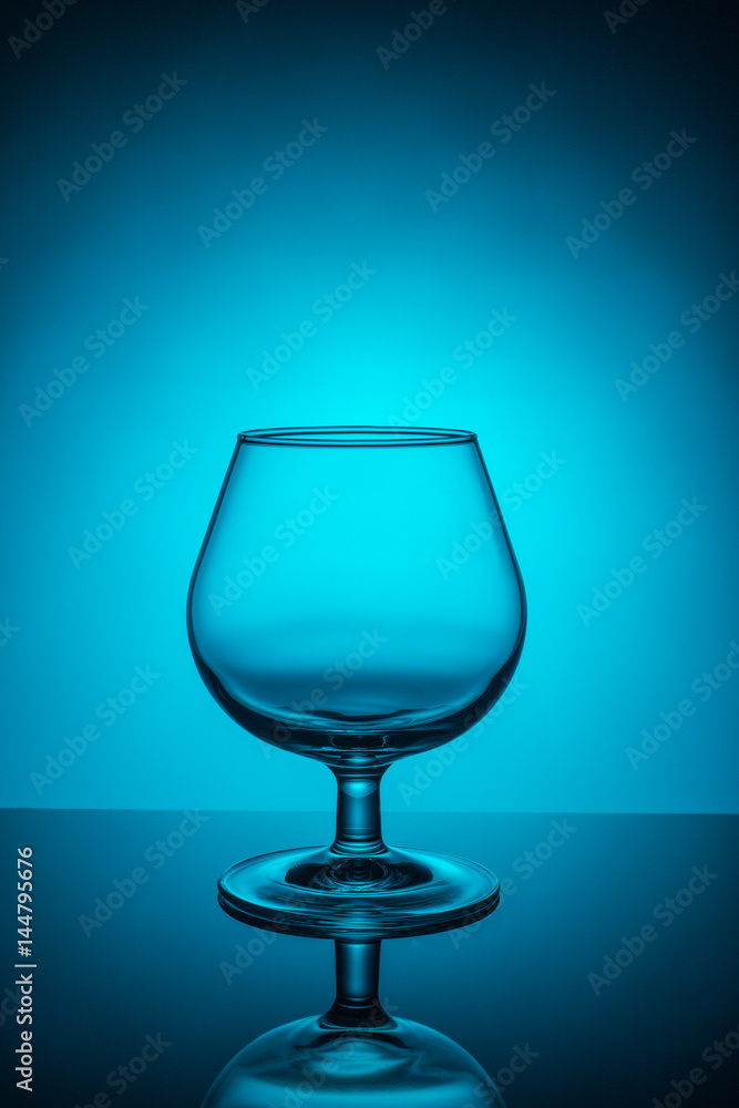 Empty wine glass on a blue background Empty wine glass on a blue background