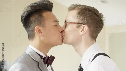  Young gay couple getting ready for wedding kiss & make heart shape with hands photo