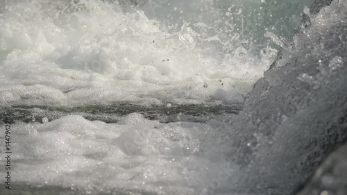 Slow motion water floating down a cascade of a river, close, in 4K photo