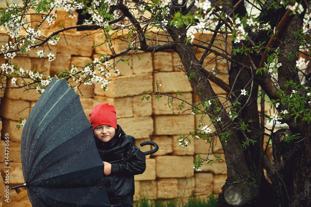 the boy holding the umbrella , the Spring walking in the rain the boy holding the umbrella , the Spring walking in the rain
