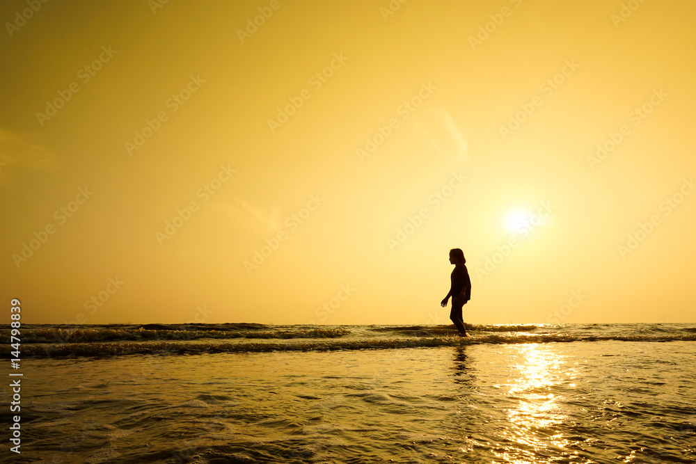 Silhouette of girl walking at the beach.