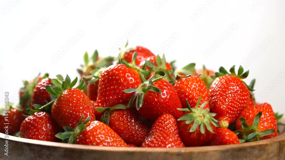 Strawberry in a wooden bowl rotates on a turntable Strawberry in a wooden bowl rotates on a turntable