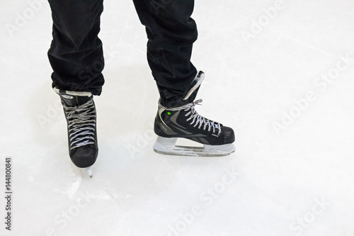 Close up male feet in skates on ice