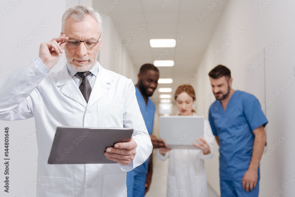 Concentrated pediatrician using modern gadget in the clinic