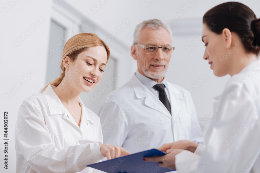 Delighted medics reading information about the patient in the clinic Delighted medics reading information about the patient in the clinic