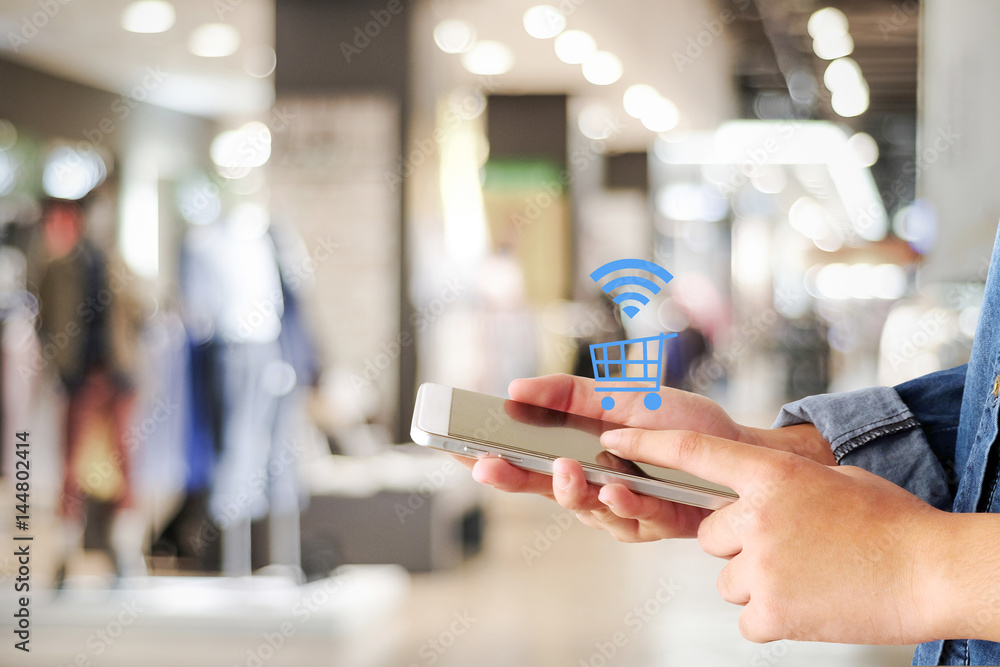 Woman hand using smart phone and shopping icon over blur store with bokeh background, shopping online and digital marketing concept Woman hand using smart phone and shopping icon over blur store with bokeh background, shopping online and digital marketing concept