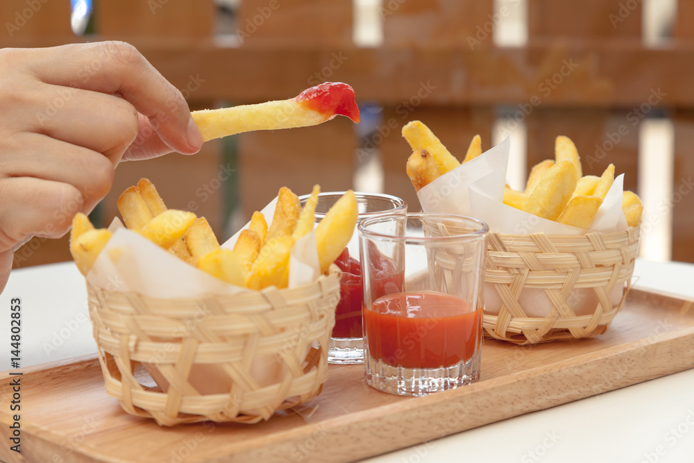 Eating french fries dipping with ketchup and chili sauce