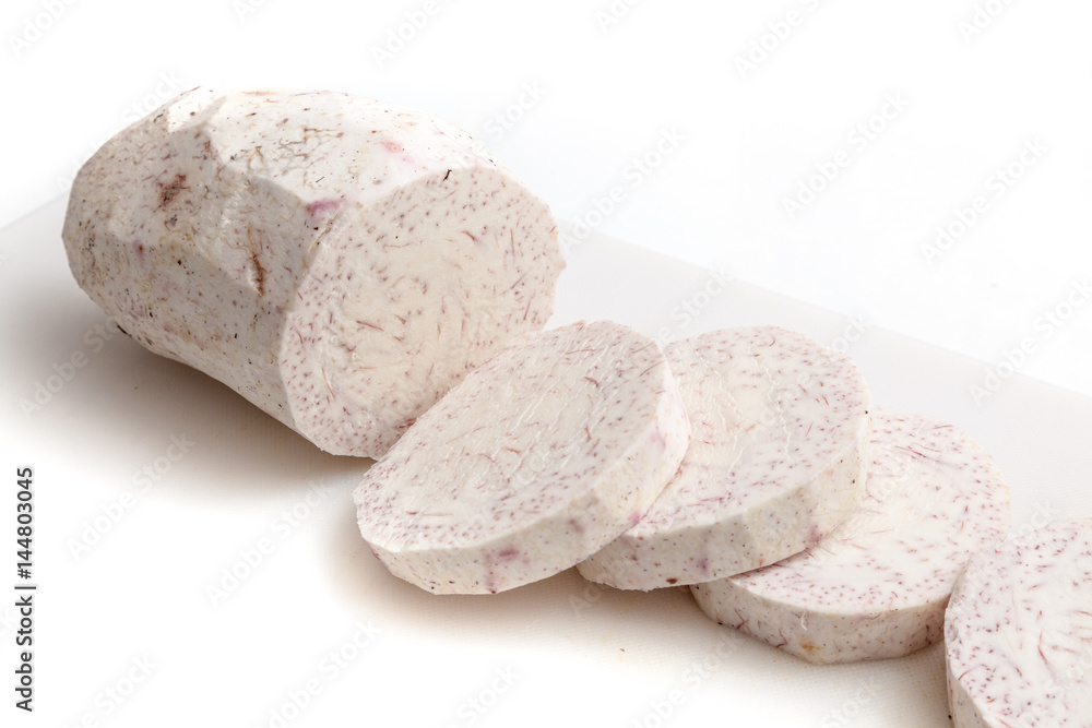 Sliced raw taro on white cutting board