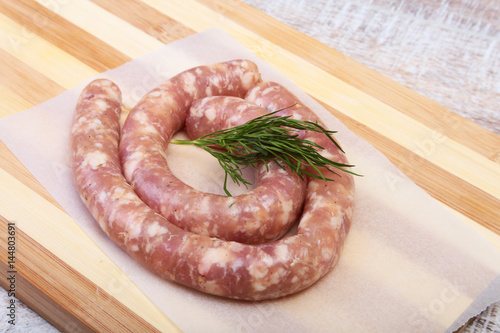 Homemade Raw sausage with spices on a wooden background.