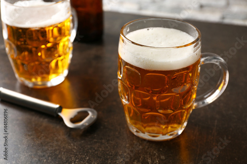 Mugs with beer on table