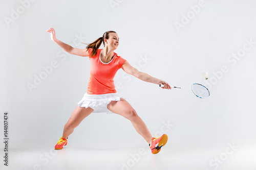 Young woman playing badminton over white background © master1305