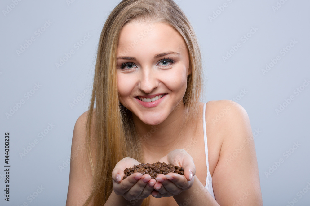 Lächelndes Mädchen mit Kaffeebohnen in der Hand Lächelndes Mädchen mit Kaffeebohnen in der Hand