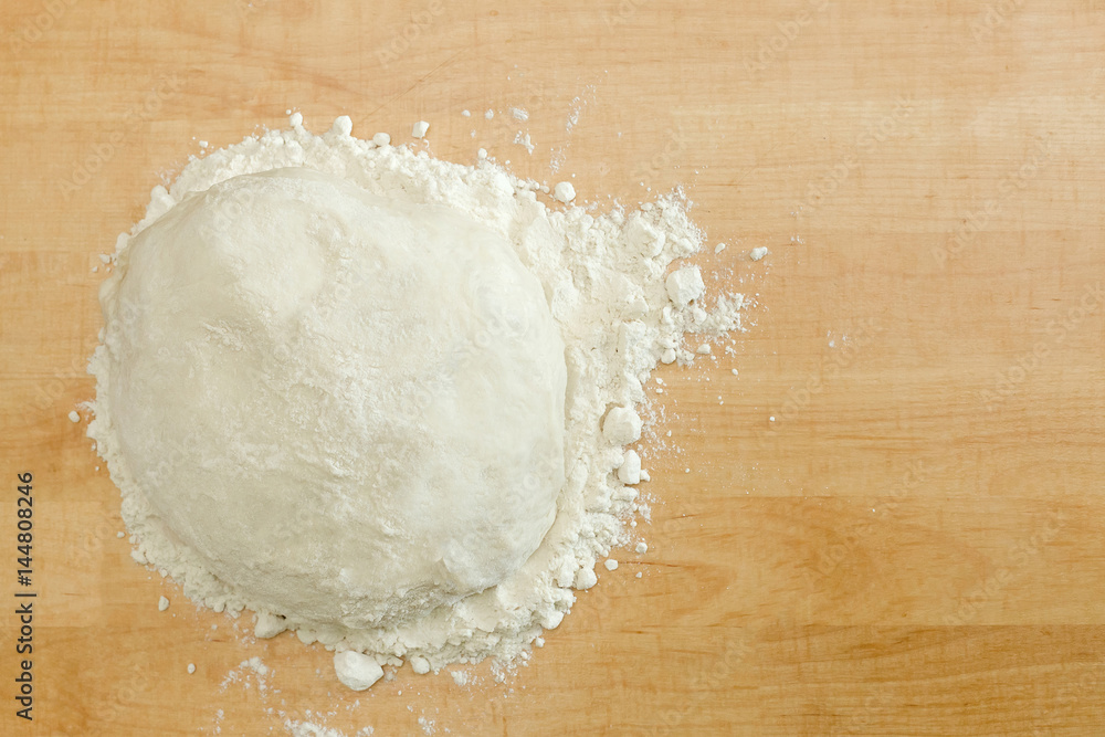 Ball of dough on wooden background with dusting of flour Ball of dough on wooden background with dusting of flour