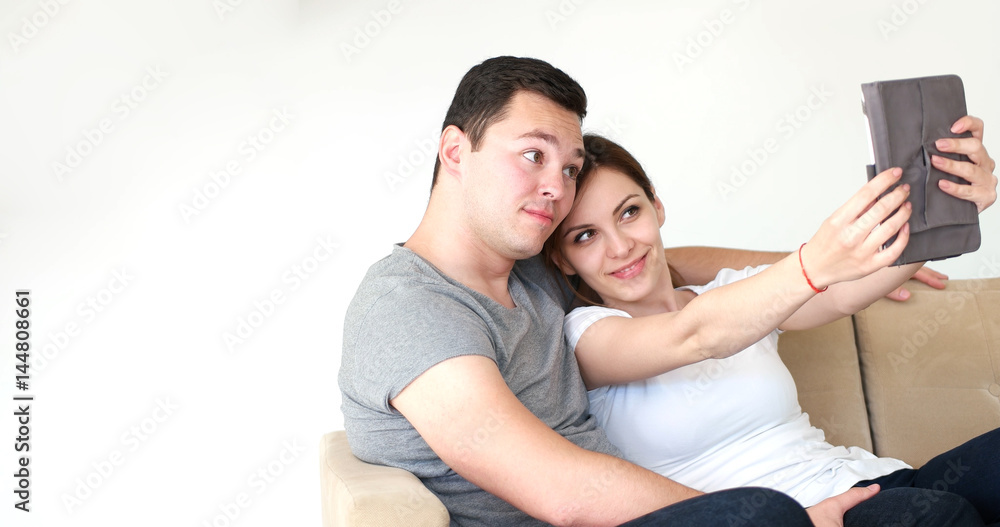 Young Couple using digital tablet at home Young Couple using digital tablet at home