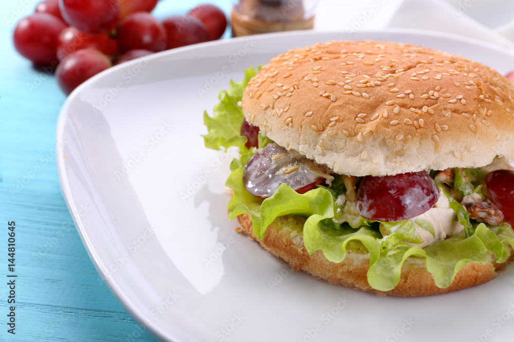 Plate with chicken salad in burger bun on table Plate with chicken salad in burger bun on table