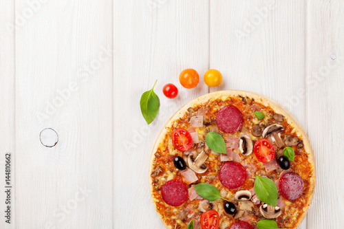 Fototapeta Naklejka Na Ścianę i Meble -  Italian pizza with pepperoni, tomatoes, olives and basil